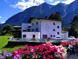 ein Gebäude mit Blumen vor einem Berg in der Unterkunft Landhaus Ambachhof in Oetz