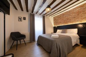 a bedroom with a bed and a brick wall at Apartamento Logroño Parlamento in Logroño