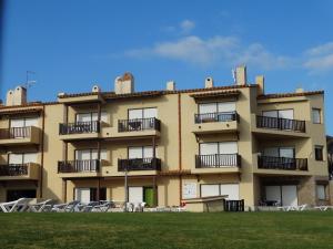 un edificio de apartamentos con sillas delante en Apartamento Punta Montgo Port de Rei, en L'Escala