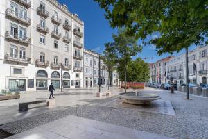 Un homme marchant dans une rue de la ville avec des bâtiments dans l'établissement Anjos Balconies, à Lisbonne