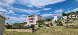 a building on top of a hill with trees at Apartmani Cesar in Rtina