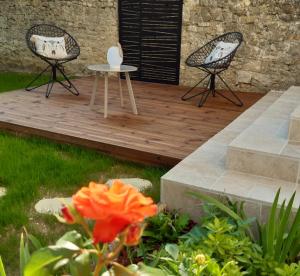 2 chaises et une table sur une terrasse en bois dans l'établissement La Clé du Puy, à Cabariot