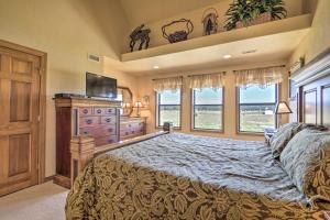 a bedroom with a bed and a dresser and windows at Hike and Fish Pagosa Springs Townhome with View! in Pagosa Springs