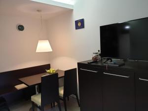 Cette chambre dispose d'une table à manger et d'une télévision à écran plat. dans l'établissement Apartma Kurji vrh - Chicken top, à Kranjska Gora