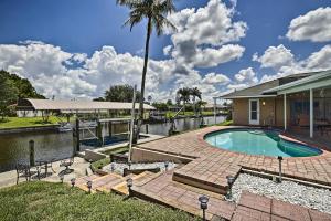 een huis met een zwembad en een palmboom bij Canalfront Oasis with BBQ, Patio, Kayaks and Dock! in Cape Coral