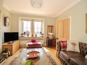 a living room with a couch and a television at Stapleton Toll in Annan