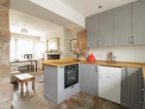 a kitchen with gray and white cabinets and a table at Stapleton Toll in Annan