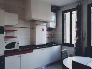 a small kitchen with white cabinets and a microwave at Calle Rielo great canal view in Venice