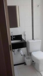 a bathroom with a white toilet and a sink at Atrius Hotel in Rio Bonito