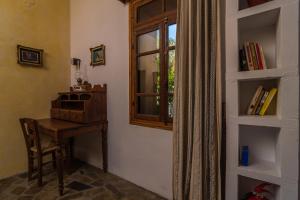 Camera con tavolo, finestra e scrivania. di Spitia Anoi a Palaiochóra