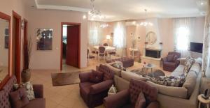 a living room with couches and a dining room at House Fox in Iraklitsa