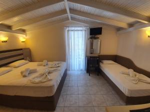 a hotel room with two beds and a television at Anna Rooms in Neos Marmaras