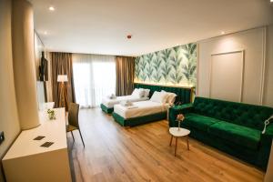 a living room with a green couch and a table at Iliad Hotel in Durrës