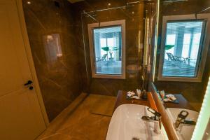 a bathroom with a sink and a shower and a tub at Iliad Hotel in Durrës +37 photos