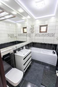 a bathroom with a sink and a tub and a toilet at Sud Dreams Apartments in Bucharest