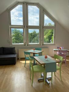 een woonkamer met tafels, stoelen en ramen bij Zimmer Paradiso in Busingen am Hochrhein