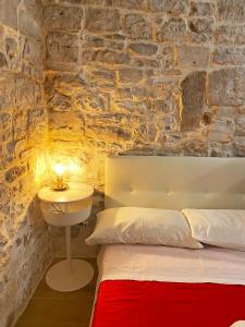 1 dormitorio con cama y pared de piedra en White Home, en Bisceglie