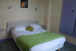 Logis Hôtel Beauséjour في شوفيني: غرفة نوم مع سرير مع بطانية خضراء عليه