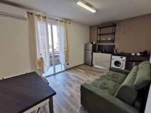 a living room with a couch and a kitchen at La Casetta Di Rosina in Caccamo