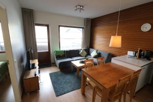 Apartment Ylläs Ski Chalets 8106, 2 Hissilippua talvella في يلاسشارفيه: غرفة معيشة مع طاولة وأريكة