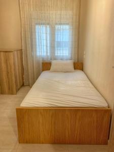 a bed in a small room with a window at Petite Luxury Urban House in Tríkala