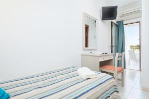 1 dormitorio con cama, escritorio y espejo en Hotel Moré, en Alcudia