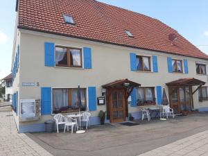 a building with blue windows and tables and chairs at Gästehaus Pension Waldhorn in Weilen unter den Rinnen +22 photos