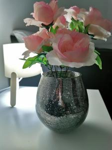 Guest House Dana في أراندجيلوفاك: مزهرية مليئة بالورود الزهرية على طاولة