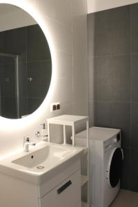 a bathroom with a white sink and a mirror at Aquamarina Prima Exclusive Suites in Międzyzdroje