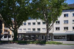 a large white building with trees in front of it at Friedrich Boutique-Apartments in Freiburg im Breisgau