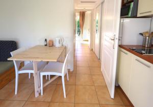 a kitchen with a table and chairs and a hallway at Orangeraie du Cap d'Antibes in Antibes