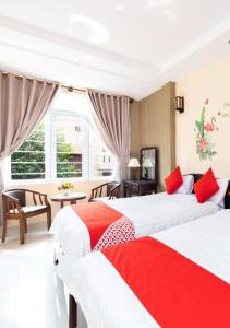two beds in a bedroom with red and white at Sao Biển Hotel in Vung Tau