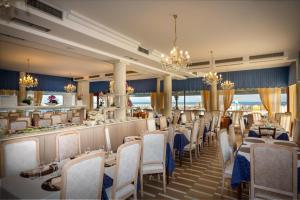 a restaurant with tables and chairs and a bar at Hotel Danieli in Caorle