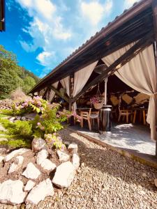 a pavilion with a table and chairs and flowers at Villa Siana in Bran