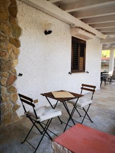 スコペッロにあるVilletta Deliziaの石壁の横に座るテーブルと椅子