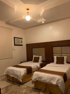 a bedroom with two beds in a room at Buyutat Najran Serviced Apartments بيوتات نجران للشقق المخدومة in Najran +10 photos