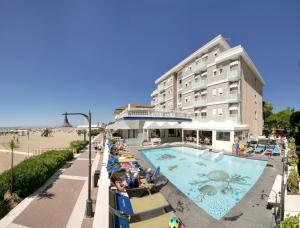 een hotel met een zwembad naast een strand bij Hotel Danieli in Caorle