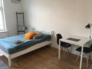 a bedroom with a bed and a desk and a table at Apartament w Centrum Olsztyna in Olsztyn