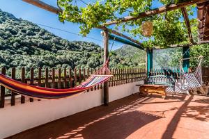 a hammock on a porch with a view of the mountains at Spitia Anoi in Palaiochora