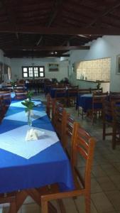 a dining room with blue tables and wooden chairs at Estancia Vale das Flores in Pacoti