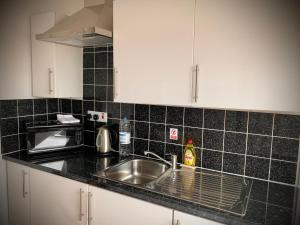 a kitchen counter with a sink and a microwave at Manchester Stay Hotel in Manchester