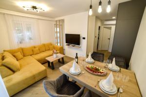 a living room with a yellow couch and a table at Luxury Apartment Knezovic in Sinj