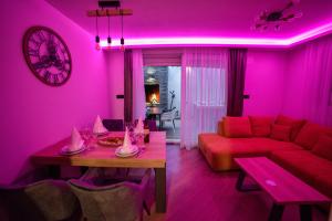 a pink living room with a couch and a table at Luxury Apartment Knezovic in Sinj