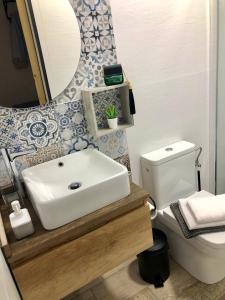 La salle de bains est pourvue d'un lavabo, de toilettes et d'un miroir. dans l'établissement Apartamentos RuiSol - AUTO CHECKIN - by Centrall alquileres turísticos, à Nerja