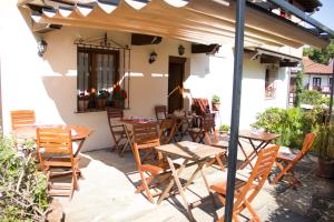 un patio avec des tables et des chaises sous une pergola dans l'établissement Pasaje San Jorge, à Comillas
