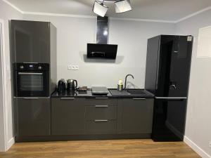 a kitchen with black appliances and a black refrigerator at Domek Maris in Międzyzdroje