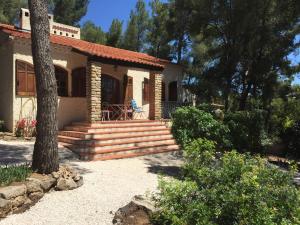 una casa con porche y escaleras delante en Villa provençale – grand jardin - 2 chambres, en Bandol