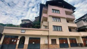 a tall building with a balcony on top of it at Vitosha Guest House in Devin