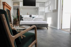 a bedroom with two beds and a chair and a couch at Fabel aan Zee in Zandvoort