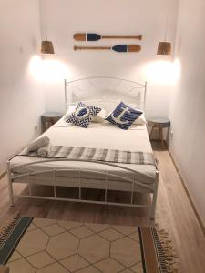 a bedroom with a white bed with blue and white pillows at Casa Mediterana in 2 Mai